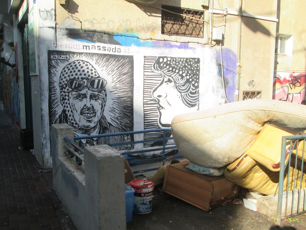 על הקיר גרפיטי בפוזה של הרחוב ומתחת הלכלוך חוגג בנוחות - רחוב מסדה בחיפה (צילום - חיים כהן)