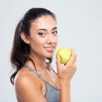 Smiling beautiful woman holding apple