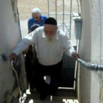 החזן מאיר בן ארוש, עולה בגרם המדרגות של בית הכנסת "שבת אחים סלוניקאים" ברחוב מרחביה בעיר. (צילום: אדיר יזירף)