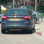 רכב חונה באדום לבן ברחוב אליעזר אלתר 12 בחיפה בעליו שם שלט חניה פרטים (צילום – חי פה)
