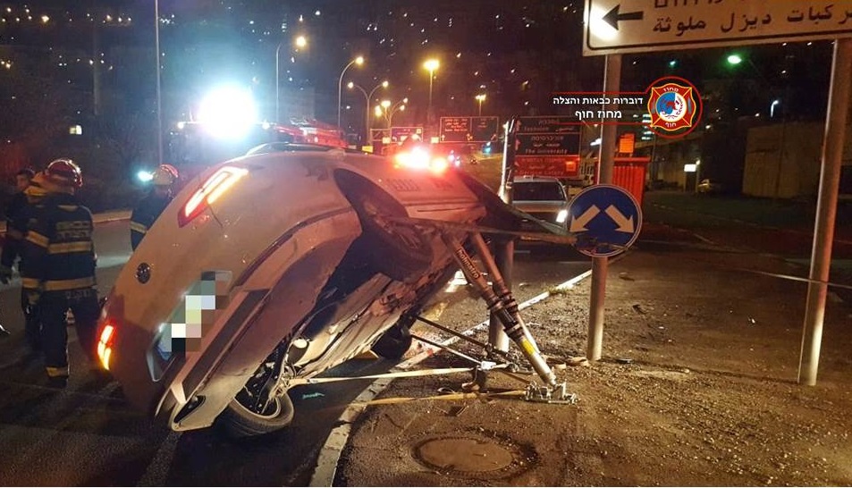 נהג מונית פגע בעמוד תאורה ונלכד ברכב הנוטה על צידו (צילום: לוחמי האש - תחנת חיפה)