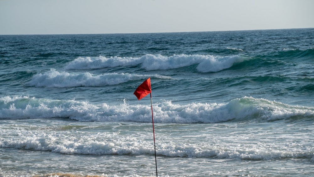 דגל אדום מונף בחוף הים של חיפה בשקיעה (צילום: ירון כרמי)