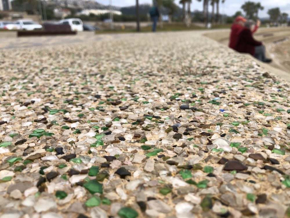 שברי זכוכיות מבצבצים מתוך הבטון בטיילת חוף הכרמל (צילום: ירון כרמי)