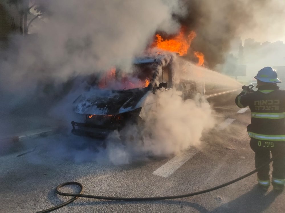 כיבוי רכב בוער - מונית מסחרית שעלתה באש בחיפה (צילום: כבאות והצלה)