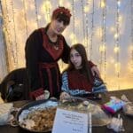 דוכן כיבוד ובו רולים במילוי חזה עוף עם בצל וסומק – דו קיום חיפאי, אירוע חג החגים בשכונת חליסה (צילום: רחלי אורבך)