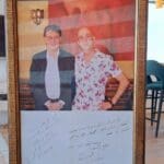 הקדשה אישית ותצלום עם המשורר מחמוד דרוויש- בביתו של פאדי נג'אר (מיסד מסעדת דוזאן) (צילום: רחלי אורבך)