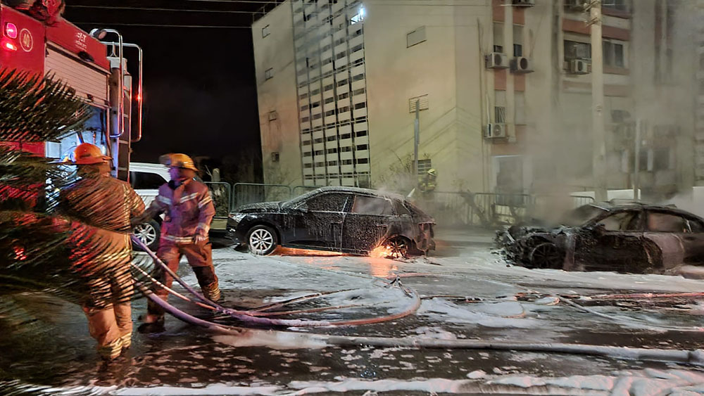 כבאים מכבים רכבים שעלו באש ברחוב טשרניחובסקי בחיפה (צילום: חי פה בשטח)