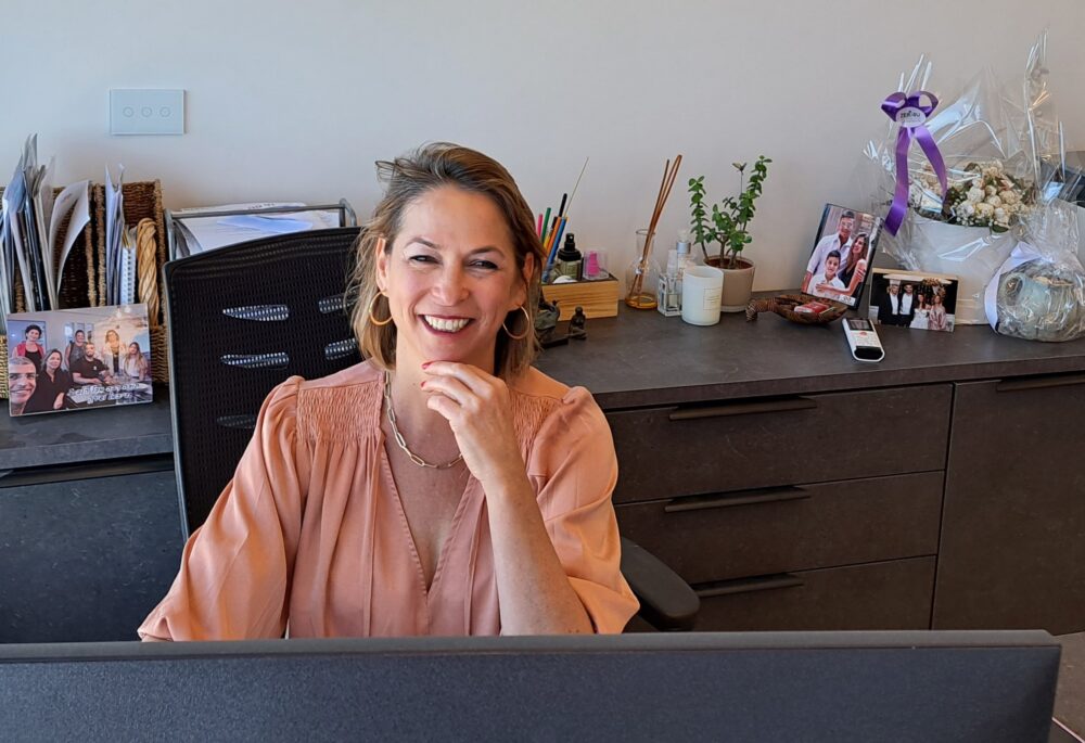 חיוך מול המחשב- בבית נגה כרמי, בעלת ומנכ"ל אתר חי פה (צילום: רחלי אורבך)