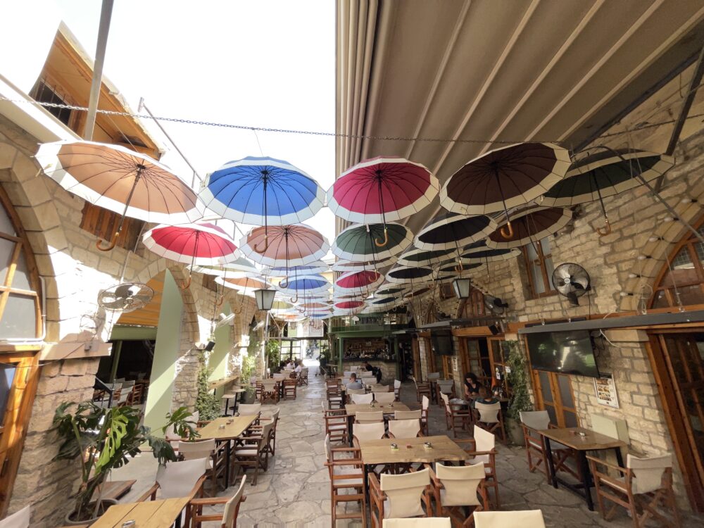בית קפה ומעליו קישוט מטריות בסמטה מרוצפת אבן - העיר העתיקה של לימסול - קפריסין (צילום: ירון כרמי)