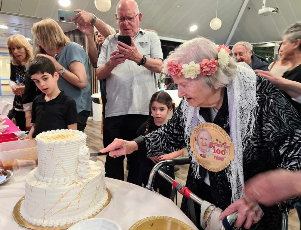 רחל פורת פורסת את עוגת יום הולדתה ה-100, חיפה אפריל 2023 (צילום: יעל הורוביץ)