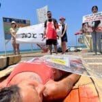 פעילי זכויות בעלי חיים ארוזים בניילון בטיילת חוף הכאמל בחיפה (צילום: פעילי "הצפון הטבעוני")