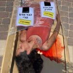 פעילי זכויות בעלי חיים ארוזים בניילון בטיילת חוף הכאמל בחיפה (צילום: פעילי "הצפון הטבעוני")