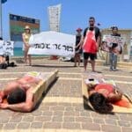 פעילי זכויות בעלי חיים ארוזים בניילון בטיילת חוף הכאמל בחיפה (צילום: פעילי "הצפון הטבעוני")