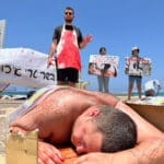 פעילי זכויות בעלי חיים ארוזים בניילון בטיילת חוף הכאמל בחיפה (צילום: פעילי "הצפון הטבעוני")
