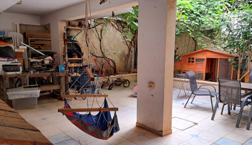 שולחן הנגרות של בועז ושאר פריטים- בחצר אשר בבית עו"ס יפעת מזרחי (צילום: רחלי אורבך)