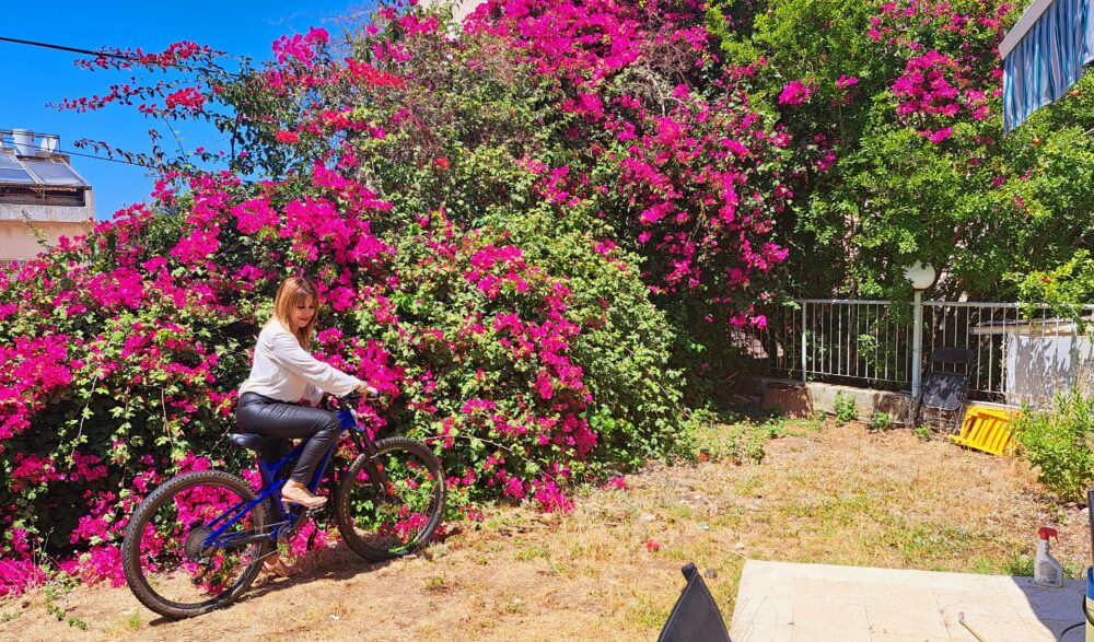 עם אופני השטח ופריחת הבוגנוויליה אשר בגינה- בבית עו"ד יעל בן דוד (צילום: רחלי אורבך)