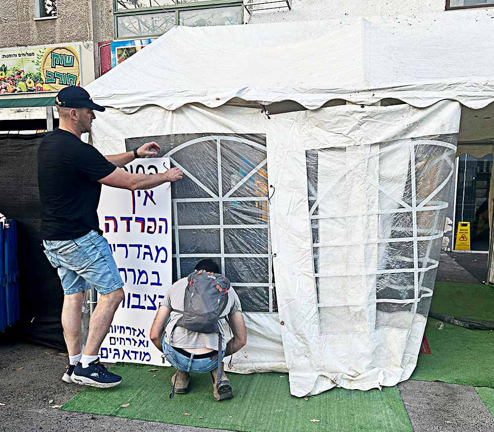חיפה: אנשי המחאה תלו שלטים ביום הכיפורים על אוהל תפילה שהוצב בצומת חורב ובו הפרדה מגדרית (צילום: מחאת העם)