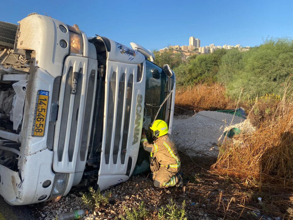 חילוץ נהג ממשאית שהתהפכה בחיפה (צילום: כבאות והצלה לישראל)