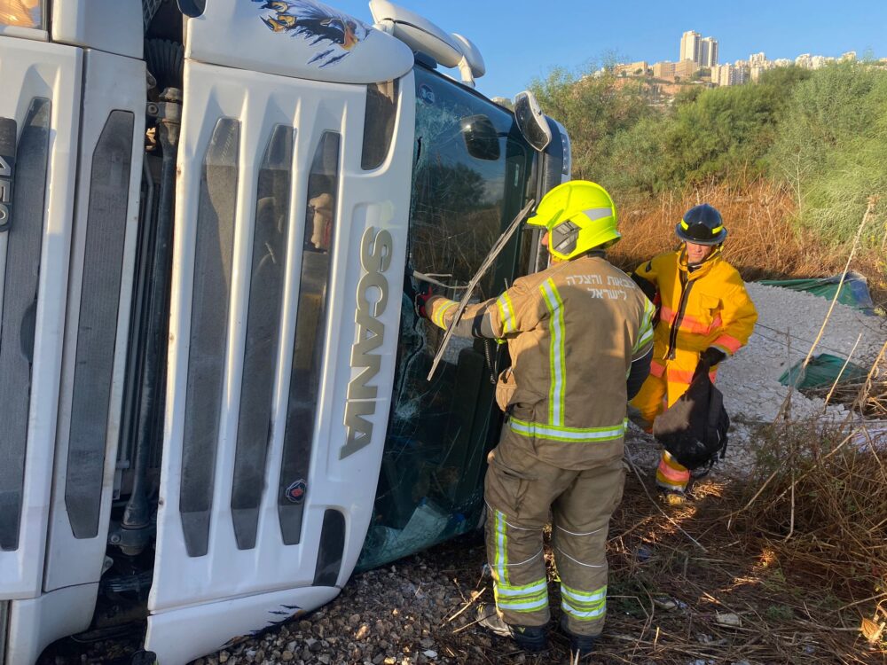חילוץ נהג ממשאית שהתהפכה בחיפה (צילום: כבאות והצלה לישראל)