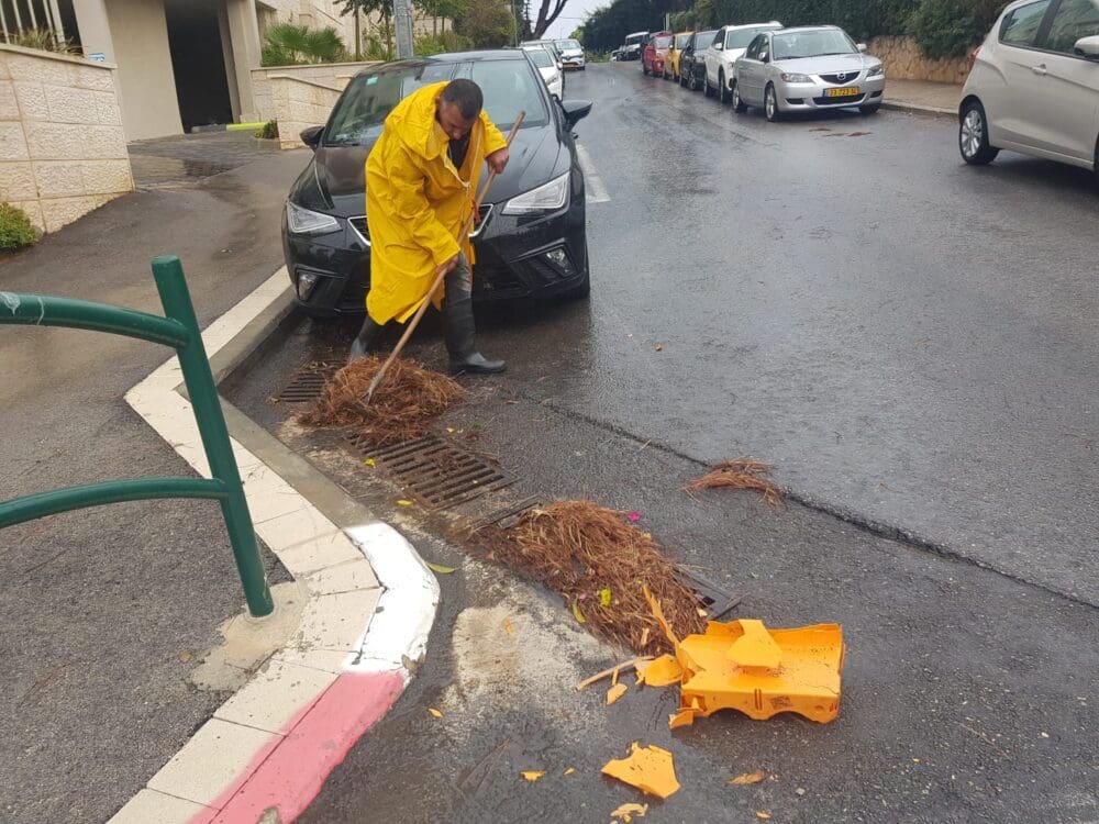 סתימות נקזים – ניקיון פתחי ניקוז מלכלוך במהלך מערכת גשם (צילום: דוברות עיריית חיפה)