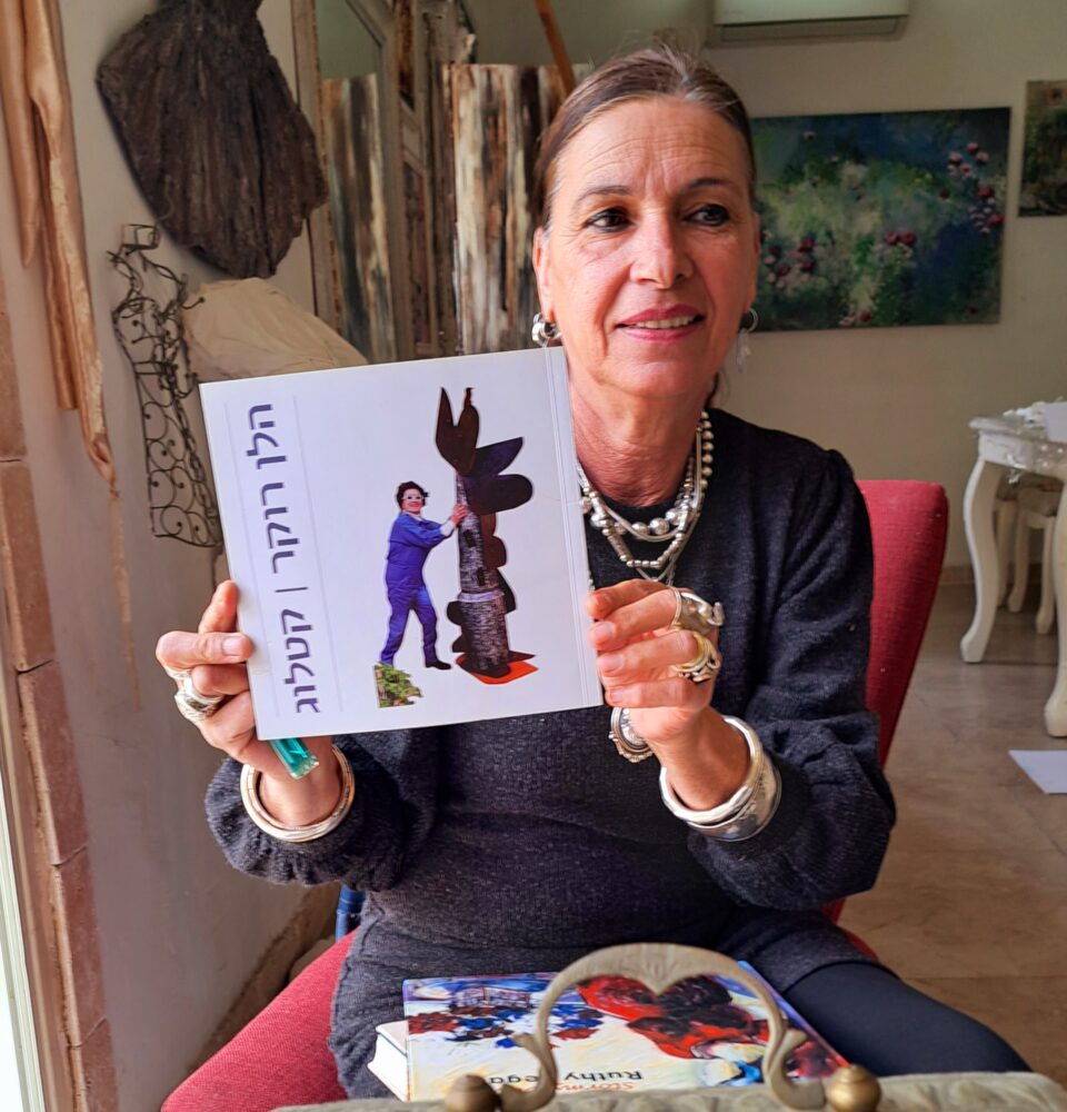 זהבה זיו אמזלג עם קטלוג עבודותיה של הלן רוקר (צילום: רחלי אורבך)
