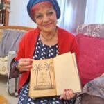 עליזה אלקיים-עבאדי – עם ספר תנ"ך עתיק יומין (צילום: רחלי אורבך)