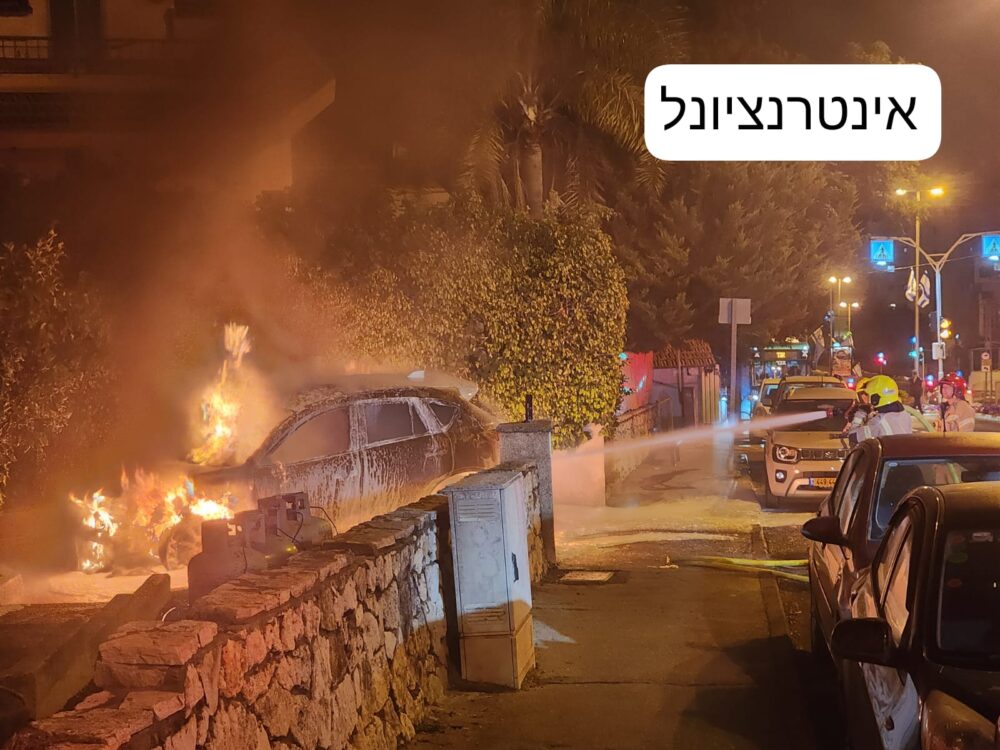 רכב עלה באש צמוד למבנה ברחוב אינטרנציונל בחיפה (צילום: כבאות והצלה)