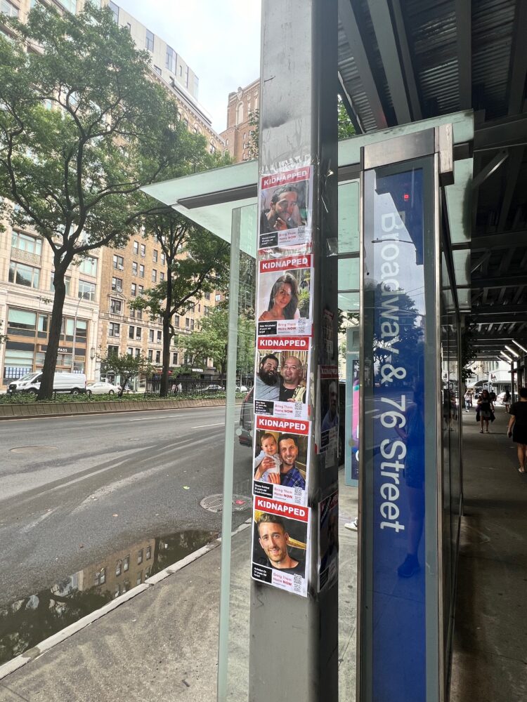תמונות החטופים מודבקות על עמודים בתחנת אוטובוס ברחוב 76 מערב. (צילום: לילי מילת)