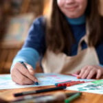 Close Up of Girl Drawing Pictures with Crayons And Enjoying Art