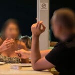 עישון בניגוד לחוק במסעדה כאשר ברקע שלט האוסר על העישון (צילום: ירון כרמי)