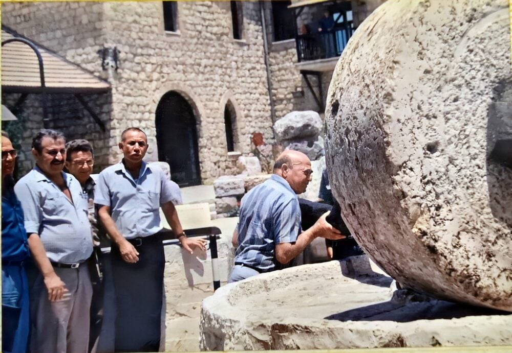 מוטקה מתקין את אבני הריחיים לתצוגה במוזיאון "שמן" (אלבום פרטי, מזכרת למשפחה) 