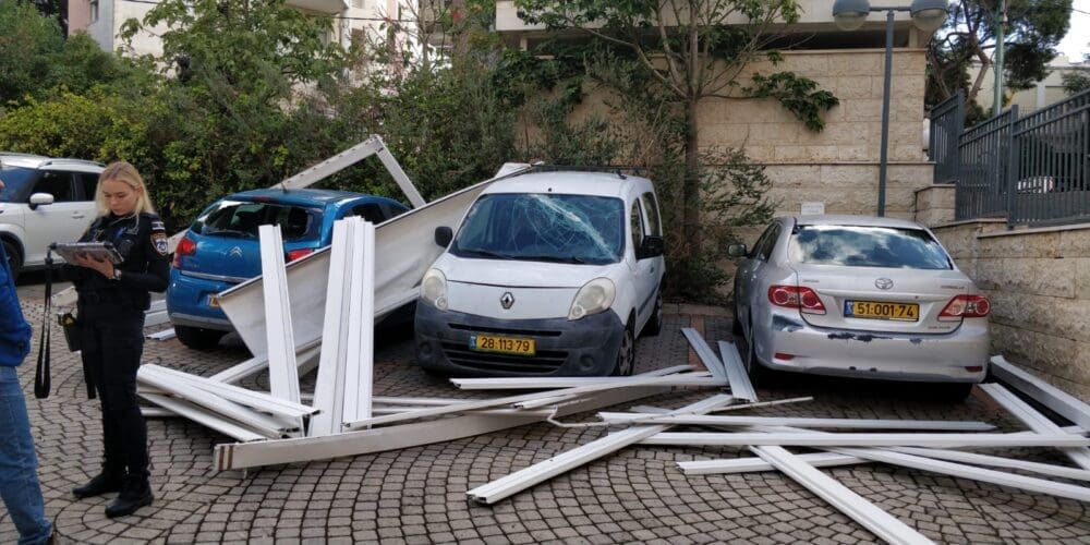 פרגולה עפה מבניין ופגעה במכוניות שעמדו בחניה (צילום: חי פה בשטח)