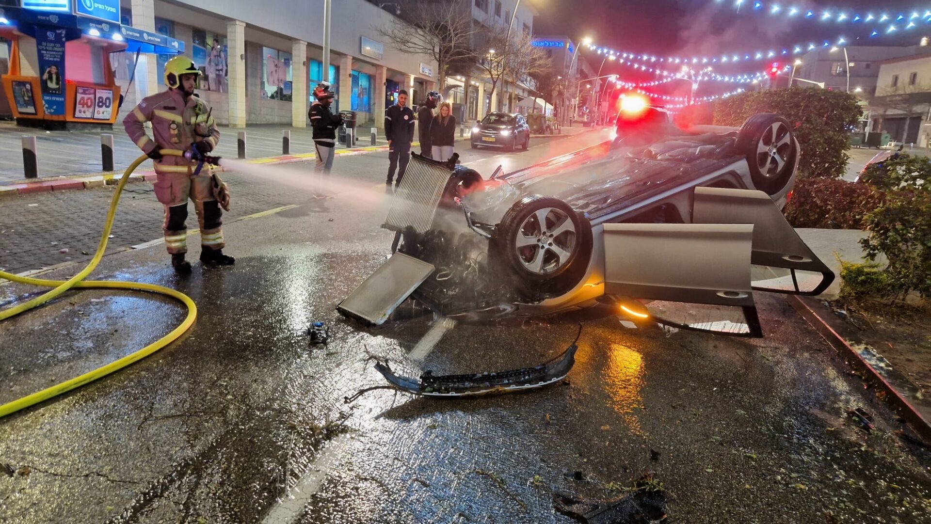 רכב התהפך ועלה באש במרכז הכרמל בחיפה. הנהג נמלט מהמקום (צילום: כבאות והצלה)