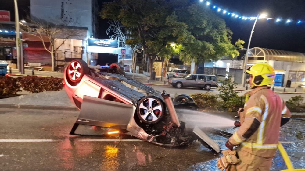 רכב התהפך ועלה באש במרכז הכרמל בחיפה. הנהג נמלט מהמקום (צילום: כבאות והצלה)