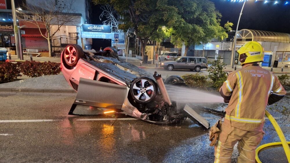 רכב התהפך ועלה באש במרכז הכרמל בחיפה. הנהג נמלט מהמקום (צילום: כבאות והצלה)