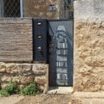 בבית יוסי קורי -שער הכניסה מעוטר בציור גרפיטי של האמן המקומי בן משיח (צילום: רחלי אורבך)