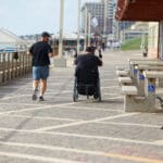 רץ ולידו חברו נכה בכיסא גלגלים בחוף דדו (צילום: שרון לייבל)