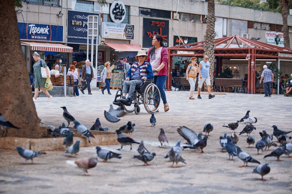 קשישה ומטפלת בכיכר מאירהוף (צילום: שרון לייבל)