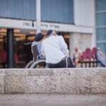 זוג חרדי עם כיסא גלגלים ברחבת התיאטרון העירוני (צילום: שרון לייבל)