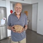 אוברי אפשטיין – ובידיו מאובן עם שרידי עצמות (צילום: רחלי אורבך)