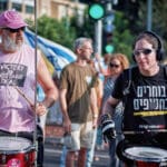 מתופפים, מתופף, רעש, ורוד, אוזניות, רמקול, תיפוף, תוף, תופים, אוקטובר, עכשיו, אמונה, החזרה, הזדהות, הפגנה, כאב, כיכר, געגוע, דגל, חמאס, חטוף, חטופים, חפים מפשע, חרבות ברזל, טרור, מלחמה, מאבק, מחאה, מחבל, מחבלים, מנהרה, מנהרות, מטה, מתגעגעים, משפחה, משפחות, עוטף עזה, עצרת, עם ישראל, פוסטרים, מדבקות, סטיקר, סולידריות, סרט, סרט צהוב, שבוי, שבויים, שביעי באוקטובר, שלט, תמיכה, צהוב, זעקה, BringThemHomeNow