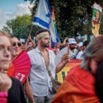 בנדנה, דגל, ענבר הימן, נרצחה, מצעד גאווה, מצעד הגאווה, גאווה, קהילה גאה, מצעד שוויון, זכויות להט"ב, קהילת הלהט"ב, דגלי גאווה, צבעי הקשת, חופש אהבה, שוויון זכויות, קהל מגוון, חגיגת גאווה, רחובות חיפה, מצעד בעיר, אהבה שוויון חופש, גיוון קהילתי, פסטיבל גאווה, גאווה בישראל, קוויר, LGBTQ