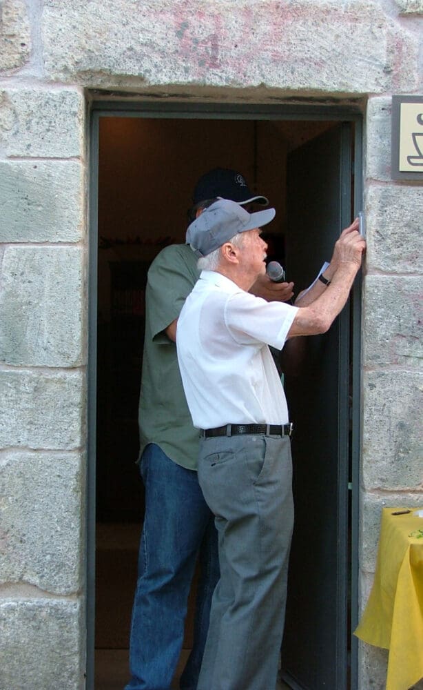 יצחק ריש קובע מזוזה בטקס שחזור האתר, ספטמבר 2005 (באדיבות בתו, דפנה קהילה)