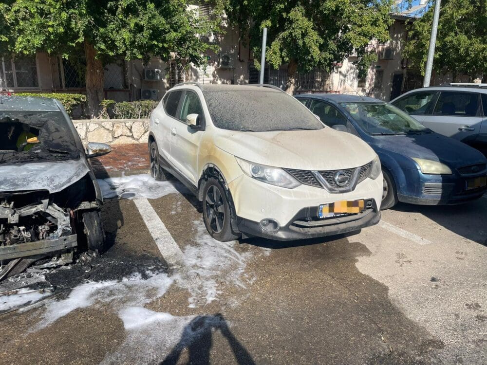 כיבוי הרכב הבוער בסמוך לרכבים חונים (צילום: כבאות והצלה)