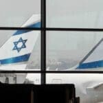 אישה מחכה בשער העלייה למטוס וברקע מטוסי של אל על – נתב״ג – שדה התעופה בן גוריון (צילום – ירון כרמי)