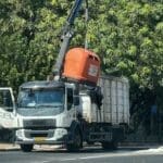 משאית איסוף פורקת מיכל מחזור פלסטיק כתום (צילום – ירון כרמי)