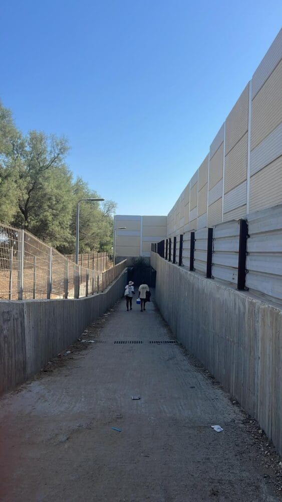 אנשים הולכים מהבית לחוף הים במעבר מתחת למסילת החוף בקיבוץ החותרים (צילום: עידו כץ)