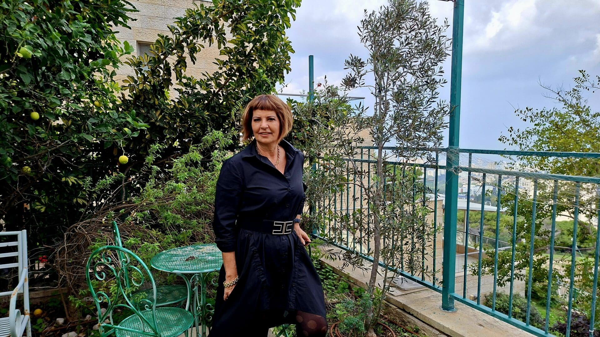 ליזט ממן פוגל - ליד עץ הזית ועצי הפרי אשר בחצר הגינה העליונה (צילום: רחלי אורבך)