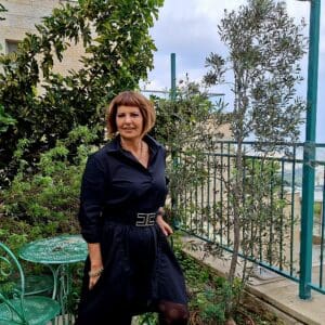 ליזט ממן פוגל – ליד עץ הזית ועצי הפרי אשר בחצר הגינה העליונה (צילום: רחלי אורבך)