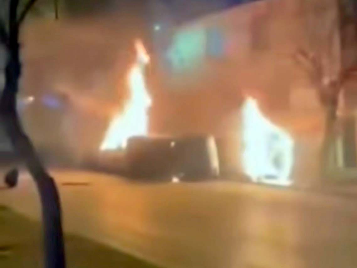 כלי רכב של המשטר האיראני עולים באש במהלך הפגנה - 1/1/26 (צילום: רשתות חברתיות באיראן)